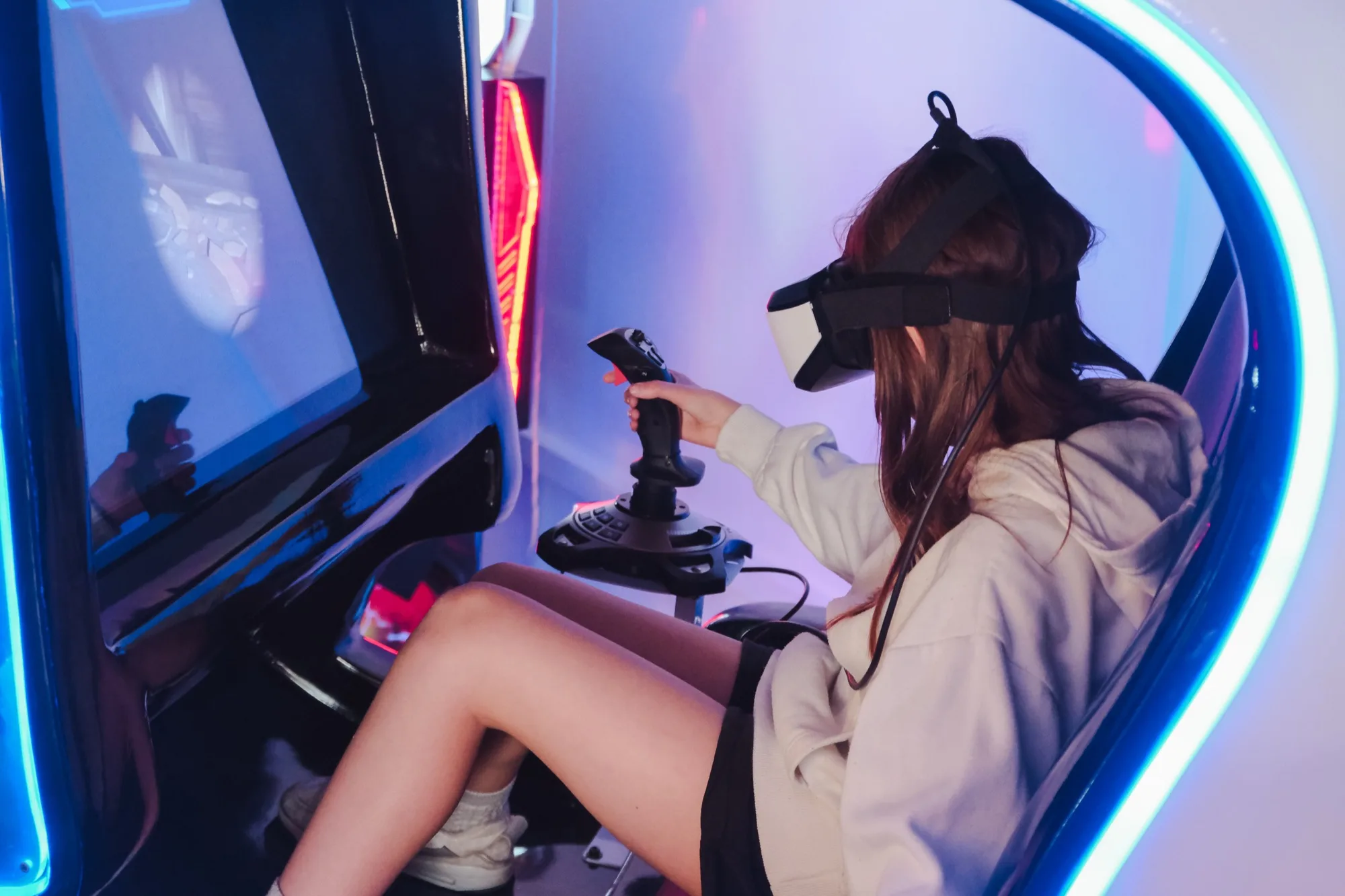 Hráčka s brýlemi pro virtuální realitu v interaktivním VR boxu